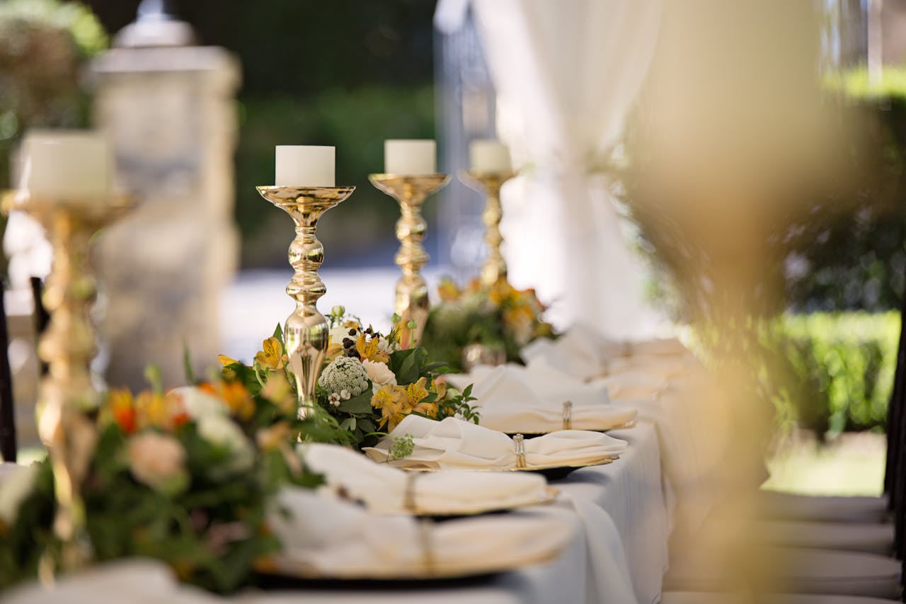 About Luxurious outdoor wedding table setting with flowers and candlesticks.
